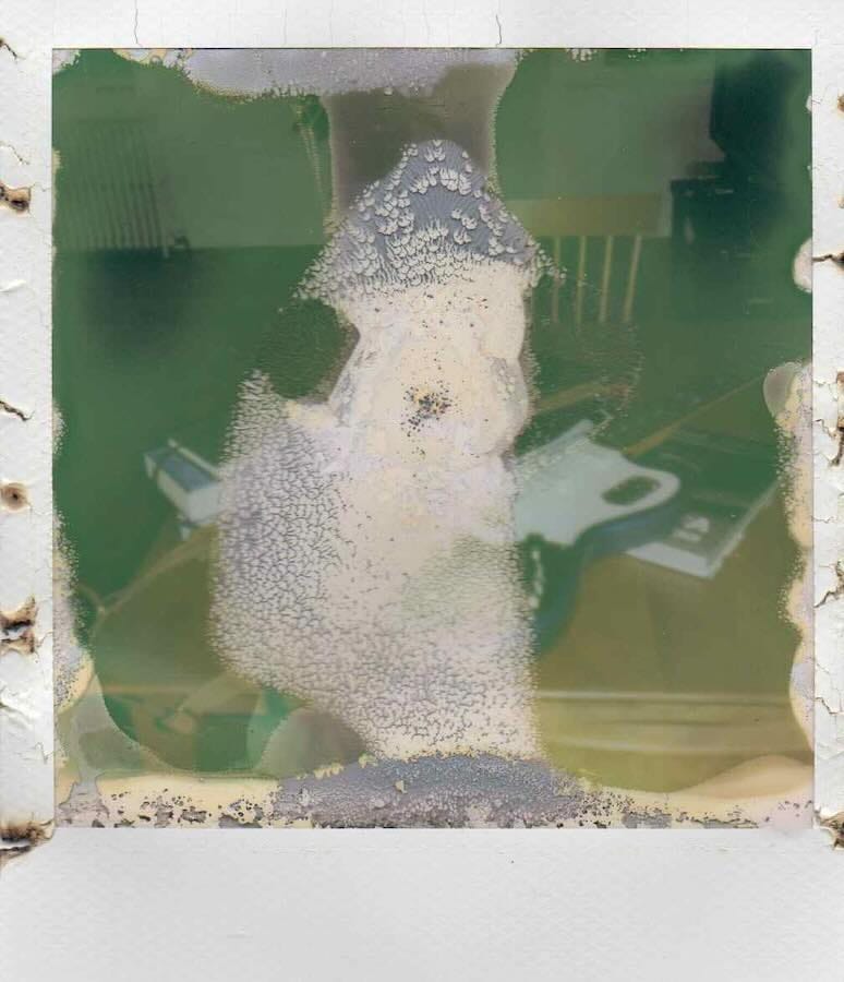 Old, damaged Polaroid photo with abstract patterns.